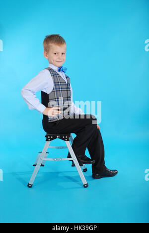 Boy in school uniform on the blue background Stock Photo