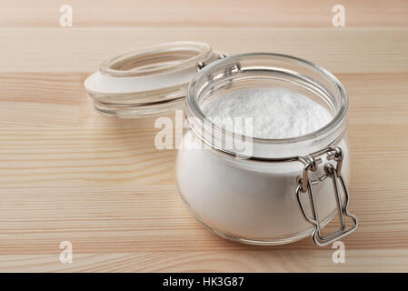 Open glass jar of baking soda on wooden background Stock Photo