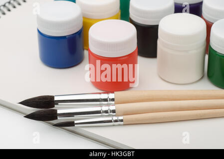 Set of acrylic paints, brushes and sketchbook Stock Photo