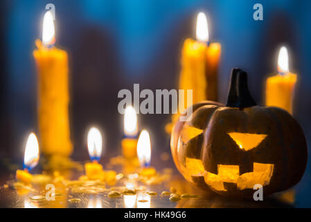 Halloween spooky Jack-O-Lantern pumpkin head with candles decoration at night background, selective focus Stock Photo