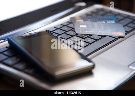 Selective focus on keyboard mobile phone and credit cards online shopping payment internet banking concept in low key dark tone Stock Photo