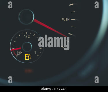 Push limits running on empty Car speedometer with word push fuel gauge with red needles and fuel light black silver red gas petrol gasoline Stock Photo