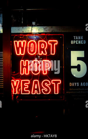 A neon sign for craft beer hangs in an urban bar Stock Photo