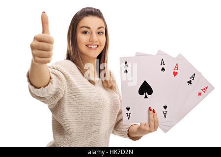 Happy girl giving a thumb up and holding four aces isolated on white background Stock Photo