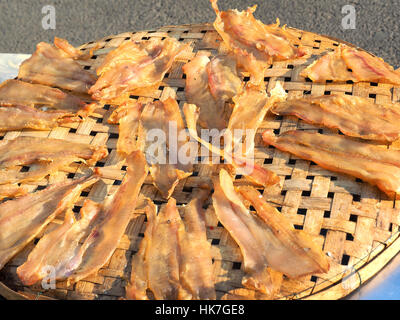 Dried fish on the bamboo grid in the sunny day , Dried fish dry in sunlight. Dried fish is dry foodstuff, this food product by mix salt with fresh fis Stock Photo