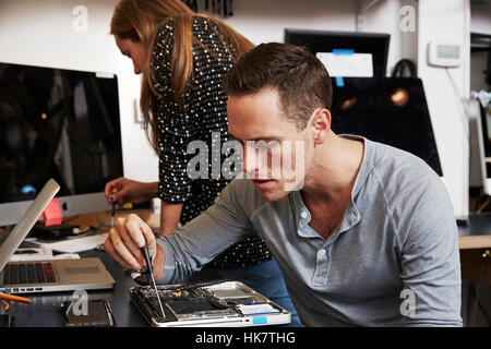 A young man and a young woman working on circuitry in a technology lab. Stock Photo