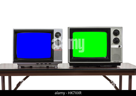 Two vintage televisions isolated on table with chroma key blue and green screens. Stock Photo