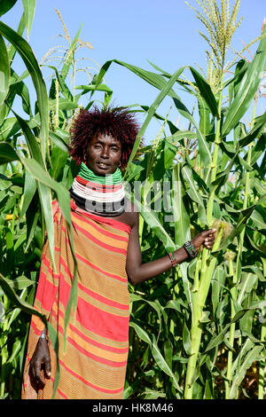 KENYA Turkana, Lodwar, Turkana village Kaitese, Turkana woman with wig in front of maize field Stock Photo