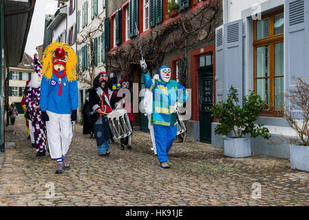 Many different groups of masked people walk through the streets of Basel for 3 days and nights at Basler Fasnacht, playing music all the time Stock Photo