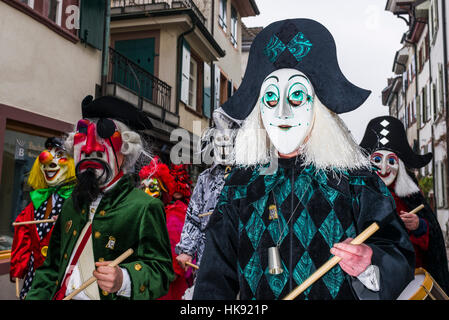 Many different groups of masked people walk through the streets of Basel for 3 days and nights at Basler Fasnacht, playing music all the time Stock Photo