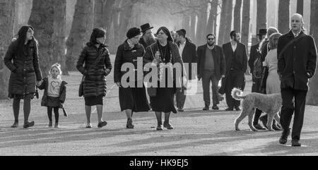 People, including a young girl, walking along The Mall. A couple are taking their dog for a walk. Stock Photo