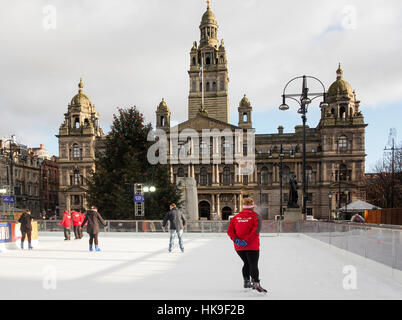 Festive skating in Glasgow George Square on temporary outdoor ice rink in front of the City Chambers. Stock Photo