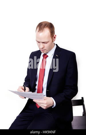 Portrait of a smiling middle aged business man holding a small binder with both hands. Vertical format isolated on white. Stock Photo