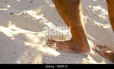 Male feet walking on sand Stock Photo