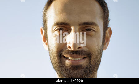 Cheerful man smiles with teeth and nods head Stock Photo