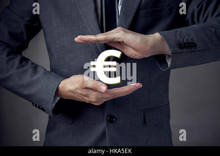 3D Euro currency sign in between two hands of businessman Stock Photo
