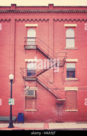 Color toned building wall with fire escape stairs, USA. Stock Photo