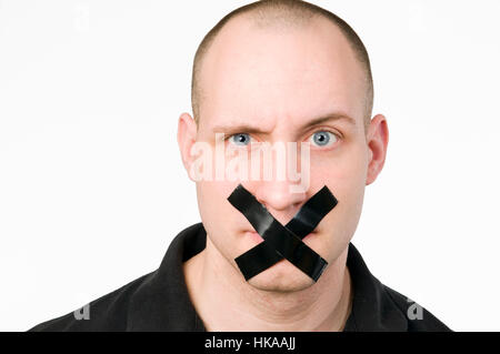 Head portrait of a young man with a mouth glued crosswise against white background. Stock Photo