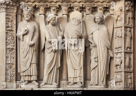 Saint Constantine the Great and Saint Denis (Dionysius) holding his head and surrounded by angels. Neo-Gothic statues on the main facade of the Notre-Dame Cathedral (Notre-Dame de Paris) in Paris, France. Damaged Gothic statues on the main facade were restored by French architects Eugene Viollet-le-Duc and Jean-Baptiste Lassus in the 1840s. Stock Photo