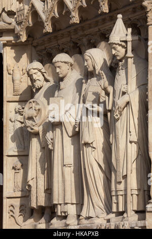 Saint John the Baptist, Saint Stephen, Saint Genevieve and Pope Saint Sylvester I (from left to right). Neo-Gothic statues on the main facade of the Notre-Dame Cathedral (Notre-Dame de Paris) in Paris, France. Damaged Gothic statues on the main facade were restored by French architects Eugene Viollet-le-Duc and Jean-Baptiste Lassus in the 1840s. Stock Photo