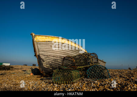 An abandoned and derelict boat on the beach at Dungeness in Kent. Stock Photo