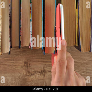 Hand taking tablet from bookshelf Stock Photo