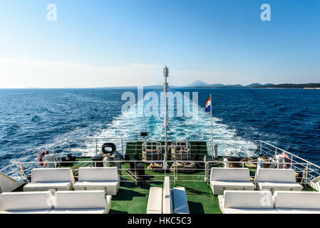 Wake water trail from a ferry ship in Croatia. Boat is leaving churning sea and waves behind. Blue ocean and skies on a sunny day. Stock Photo