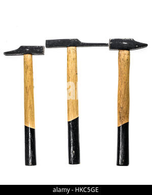 Three old, used hammer isolated on a white background. Black and yellow working tool with wooden handle and metal head. Stock Photo
