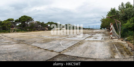 Old abandoned school sports court or  for different activities. Ruins of a sport venue abandoned long time ago with soccer, handball or foot Stock Photo