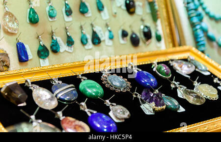Display with different designs of handmade jewelry on stand. Close-up of handmade jewelry shop window display or jewelry box Stock Photo