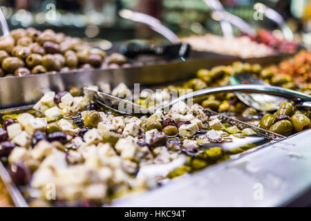 Green olives and feta cheese in oil in bar macro closeup showing detail Stock Photo