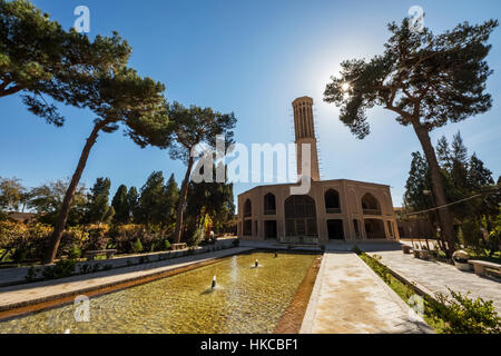 Pool along the central axis with the summer pavilion with a tall wind tower (badgir) in the background, Dolat Abad Garden; Yazd, Iran Stock Photo