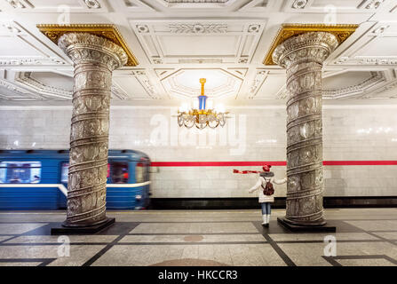 Tourist woman with red scarf and train leaving station in subway Avtovo in Saint Petersburg, Russia Stock Photo