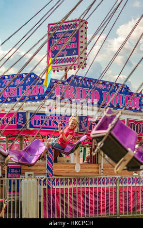 A little girl enjoys the flying chair ride at the Connecticut County Fair in Bradford, VT, USA. Stock Photo