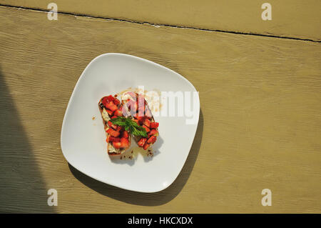Sandwiches on white plate on brown table Stock Photo