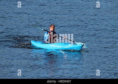 A kayaker in a blue Dagger Zydeco kayak, enjoying the waters of the Firth of Clyde in Scotland. Stock Photo