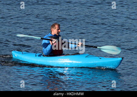 A kayaker in a blue Dagger Zydeco kayak, enjoying the waters of the Firth of Clyde in Scotland. Stock Photo