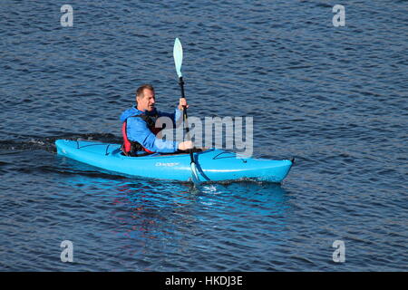 A kayaker in a blue Dagger Zydeco kayak, enjoying the waters of the Firth of Clyde in Scotland. Stock Photo