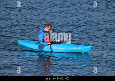 A kayaker in a blue Dagger Zydeco kayak, enjoying the waters of the Firth of Clyde in Scotland. Stock Photo