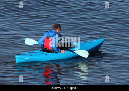 A kayaker in a blue Dagger Zydeco kayak, enjoying the waters of the Firth of Clyde in Scotland. Stock Photo