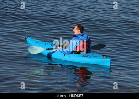 A kayaker in a blue Dagger Zydeco kayak, enjoying the waters of the Firth of Clyde in Scotland. Stock Photo