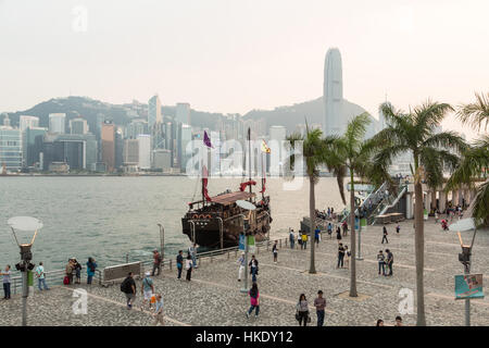 Hong Kong, Hong Kong - April 26 2015: Tourists take pictures and enjoy the famous Hong Kong island skyline across Victoria Harbour from the avenue of  Stock Photo