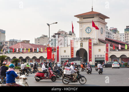 HO CHI MINH CITY, VIETNAM - FEBRUARY 2 2016: Cars and motorcycles rush around the Saigon Central Market known locally as Ben Thanh. Stock Photo