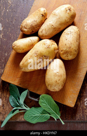 new potatoes on the old wooden background. with sage .rural style. Stock Photo