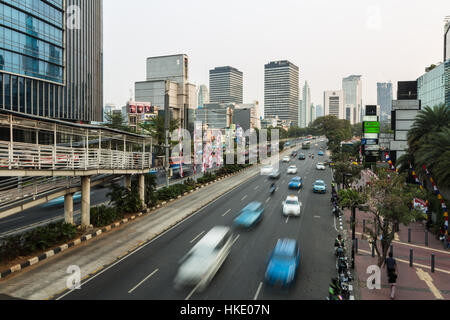 JAKARTA, INDONESIA - AUGUST 19, 2015: Traffic, captured with blurred motion, rushes through the modern business district of Jakarta in Indonesia capit Stock Photo