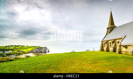 Etretat village, Church Notre Dame de la Garde chapel and Aval cliff. Normandy, France, Europe. Stock Photo