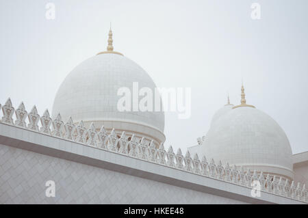 White domes of a mosque in Abu Dhabi against a foggy sky Stock Photo