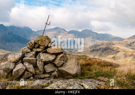 View of the Scafells in the English Lake District with a cairn in the foreground. Stock Photo