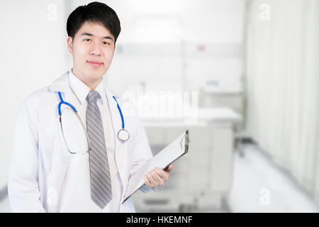Asian doctor in ward holding a clipboard at modern hospital. Medical and doctor concept. Stock Photo