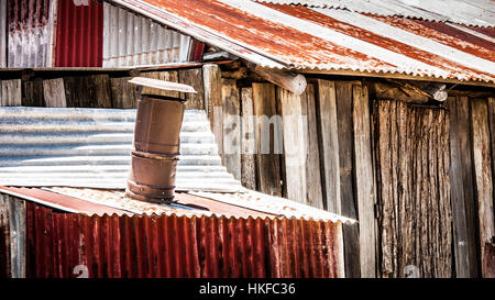 Rusted iron roofing and timber cladding close up with chimney Stock Photo